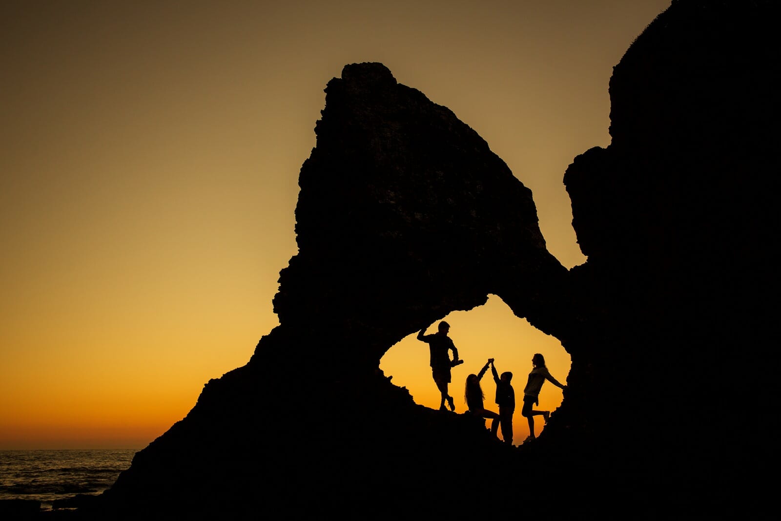 The Woods family silhouetted under a rock