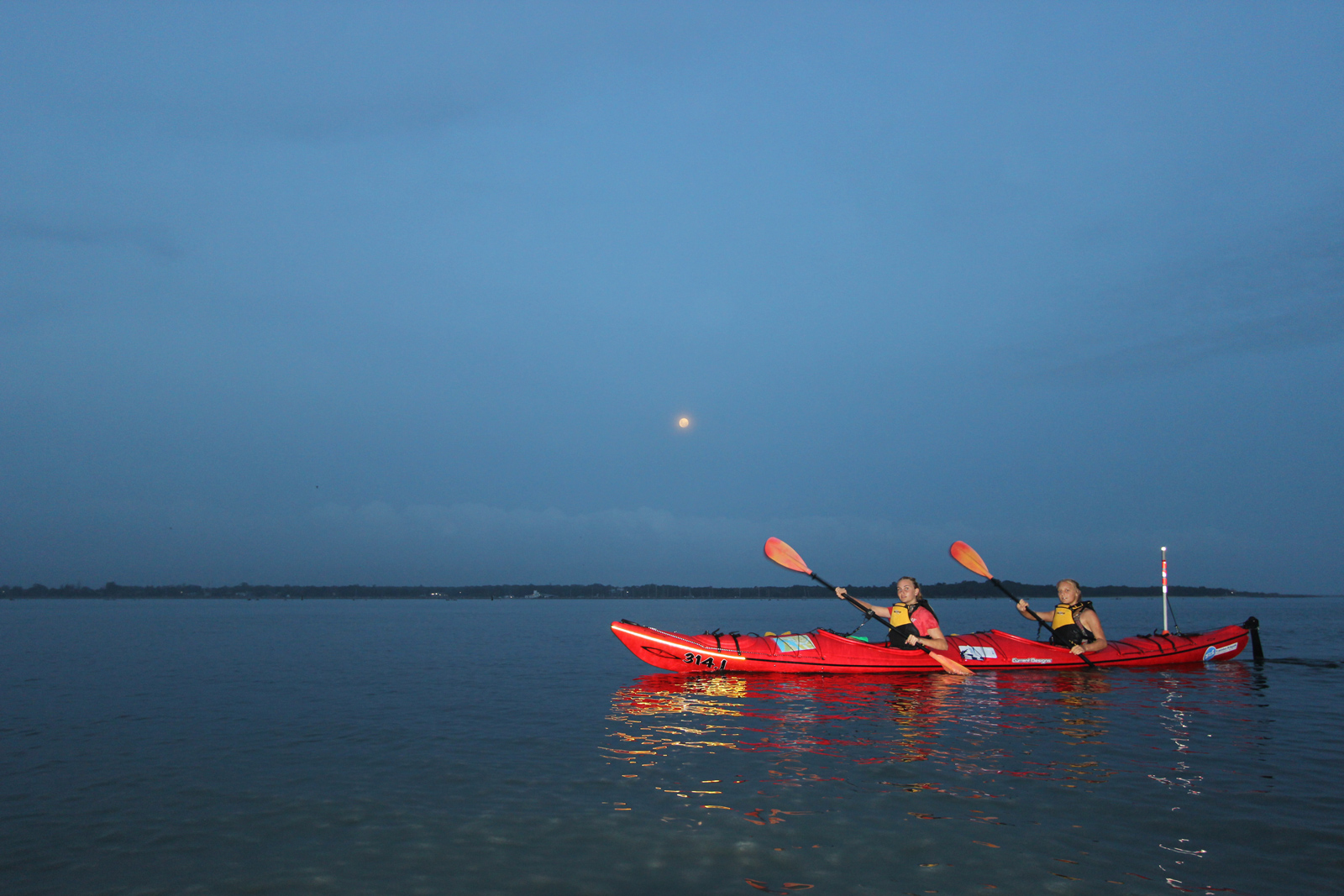 Kayaking beneath a full moon