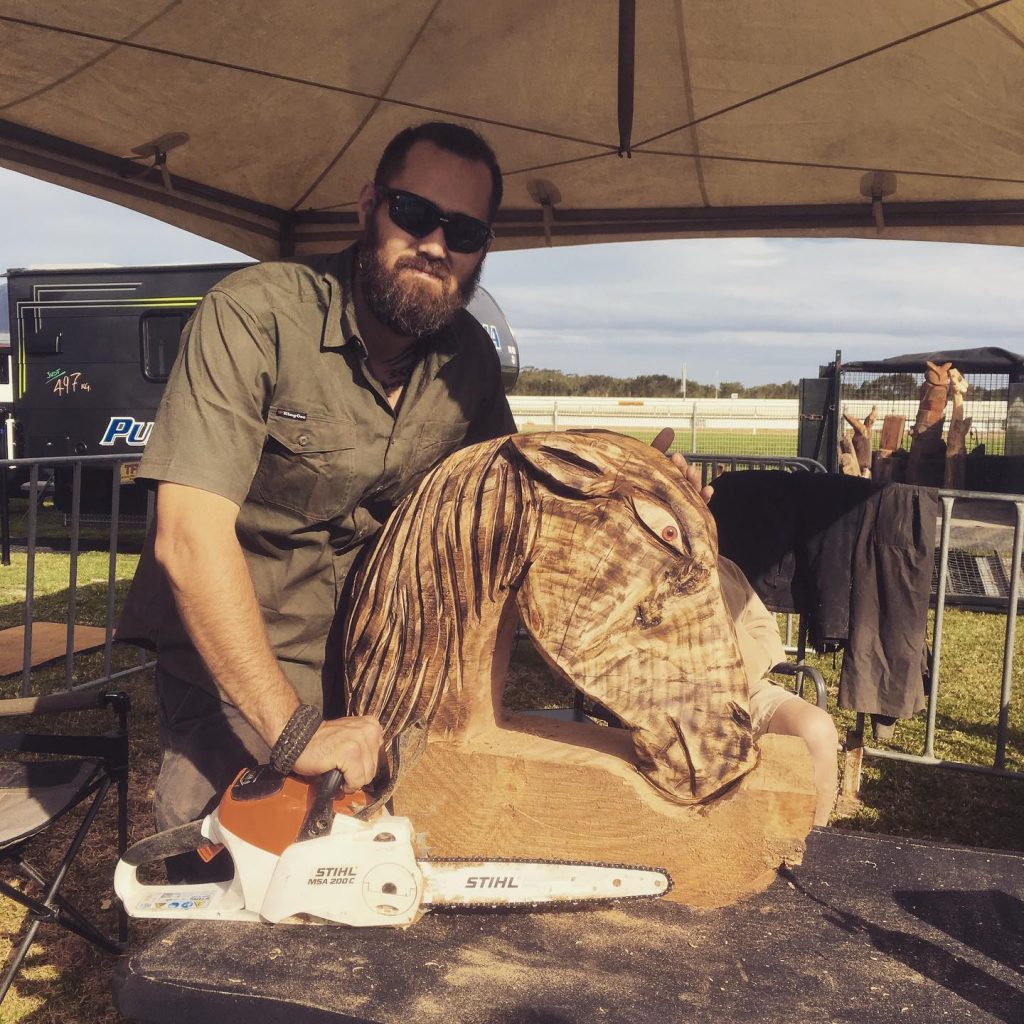 Justin Rullis with one of his wood sculptures.