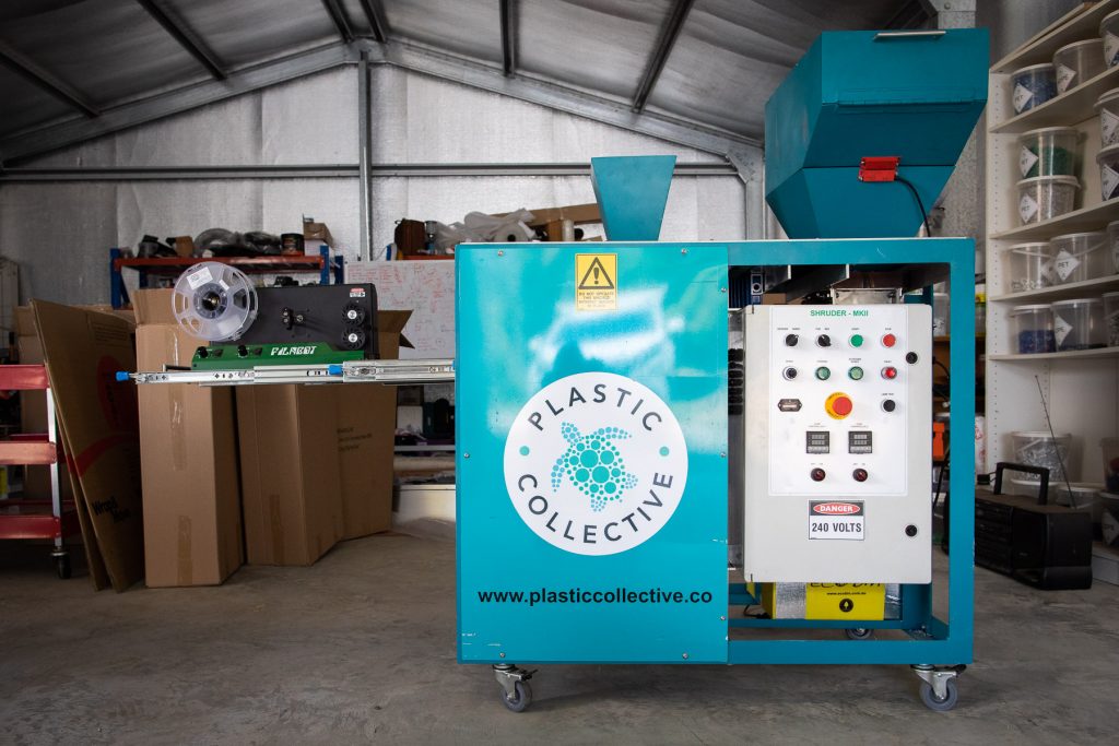 The Plastic Collector's blue Shruder machine in a garage.