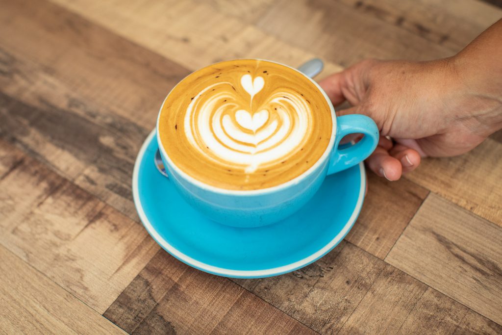 A flat white in a blue cup at Bookface Cafe Port Central 