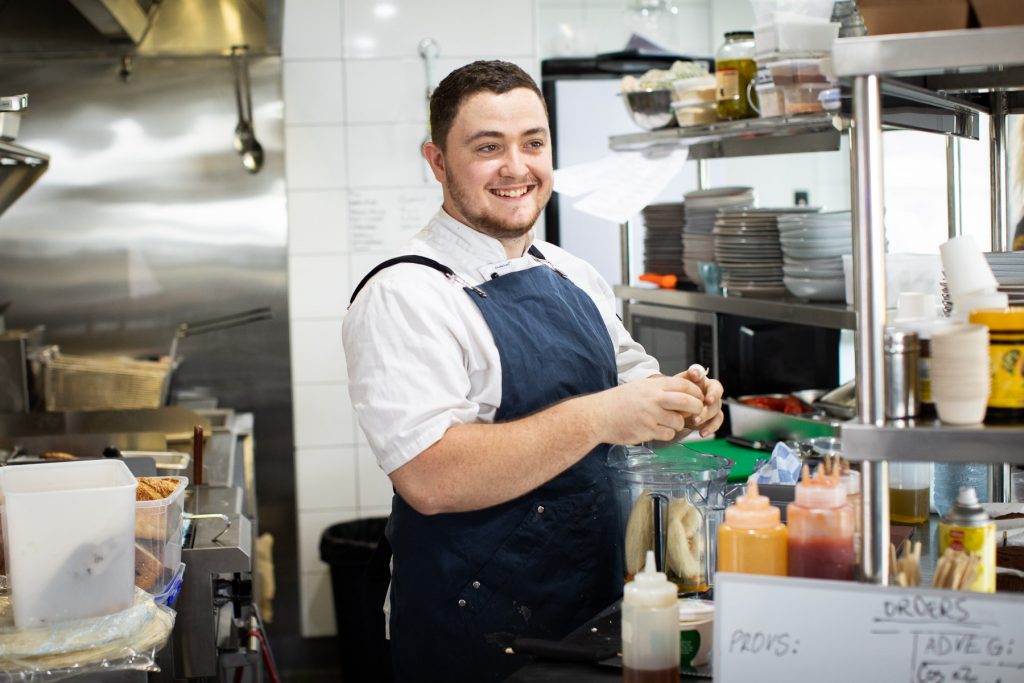 The chef at Hub Cafe prepares food in the kitchen