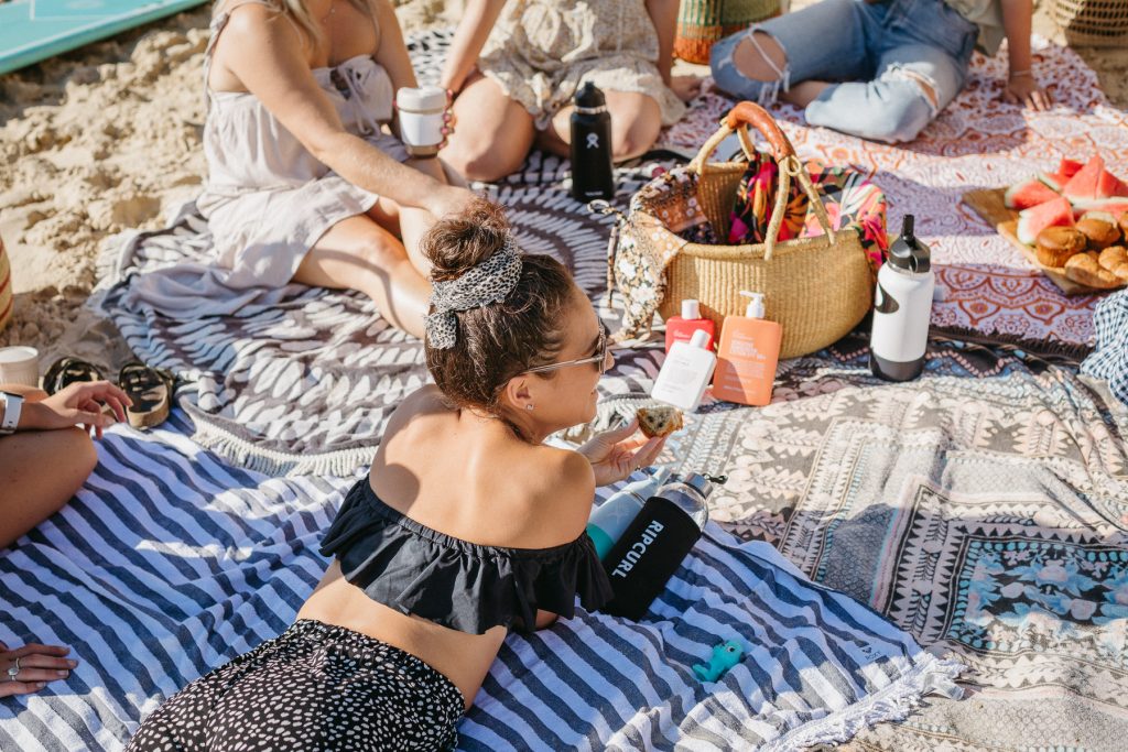 A woman lying on her stomach on a towel at the beach