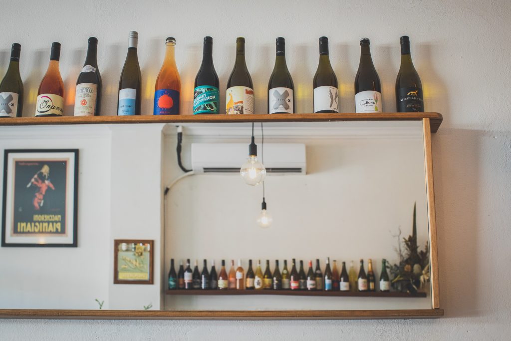 A mirror lined with wine bottles at Bar Que Sera Sawtell