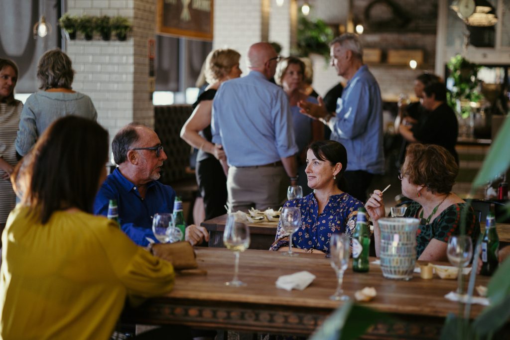 A group of people sitting at a table drinking wine 