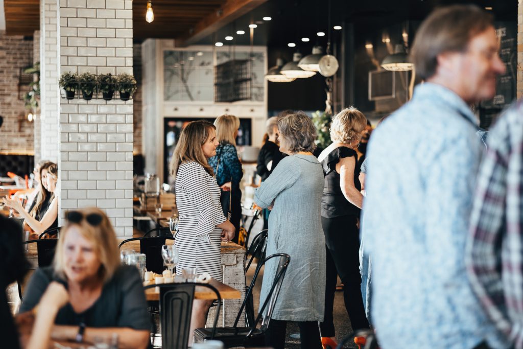 People standing up and chatting at a restaurant