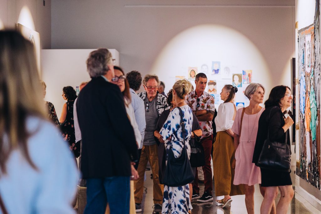 Large group of people at art exhibition opening 