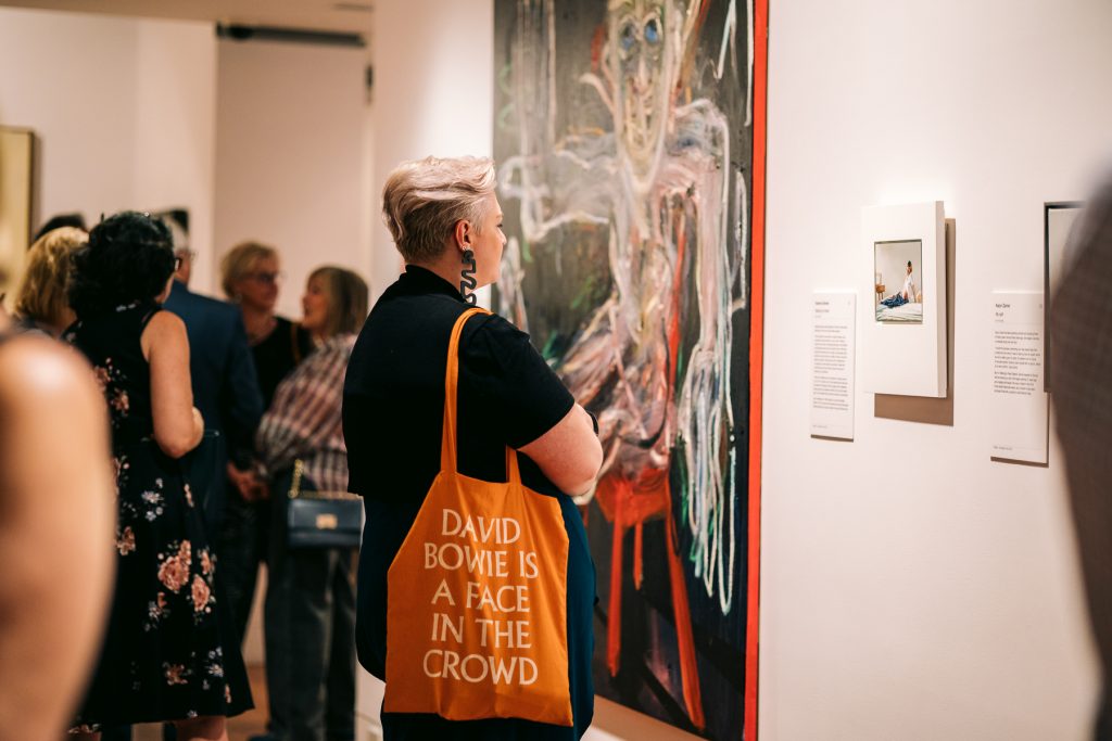 Woman looking at art on a gallery wall