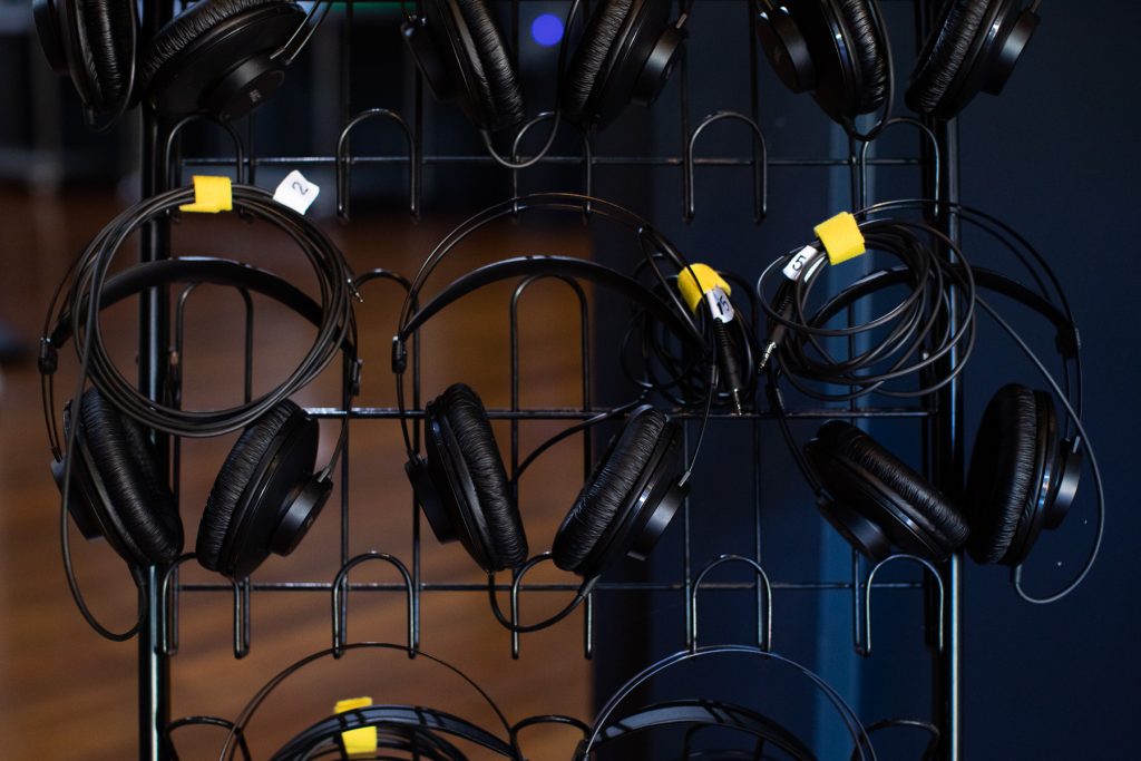 Close up of headphones hanging on a wire rack 