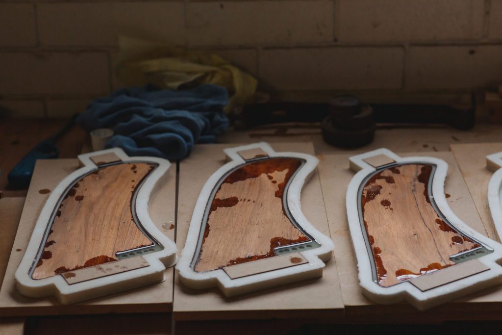 Three wooden surfboard fins in resin