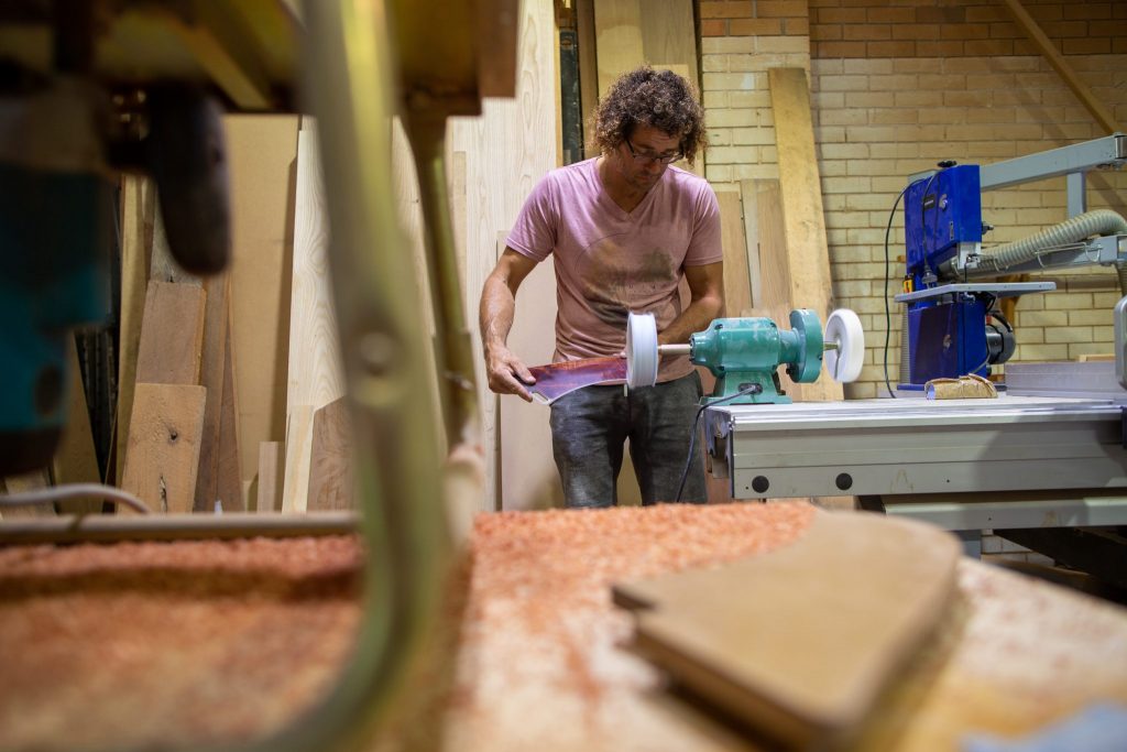 Mid shot of a man sanding wood