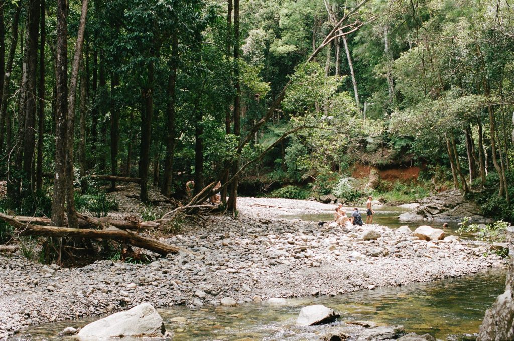 People sitting beside a rocky creek 