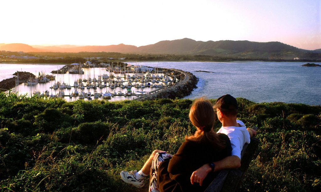 Landscape shot of a couple on Muttonbird Island overlooking Coffs Harbour Marina