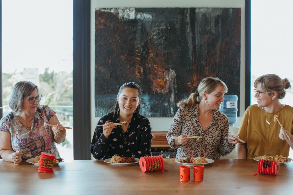 Four women at a table eating Chinese food