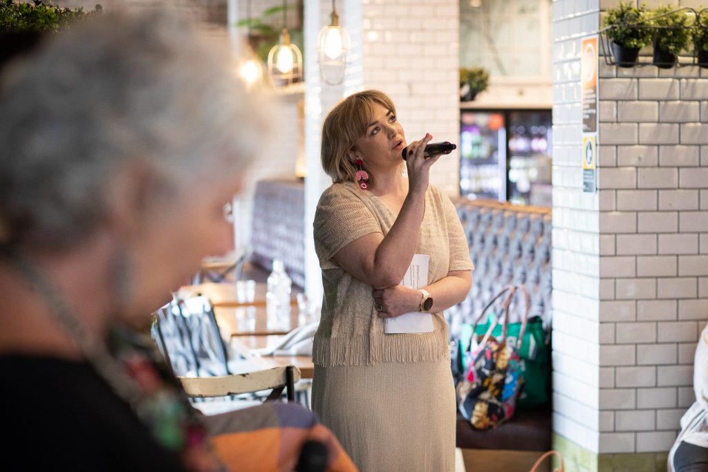 Mid shot of a woman speaking into a microphone