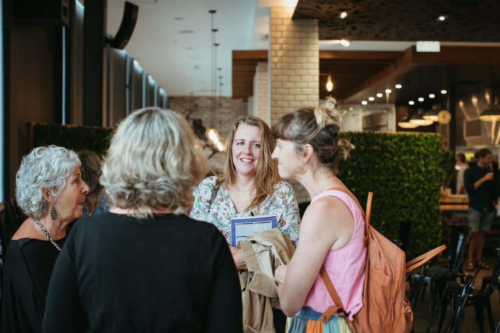 A group of women smiling and chatting