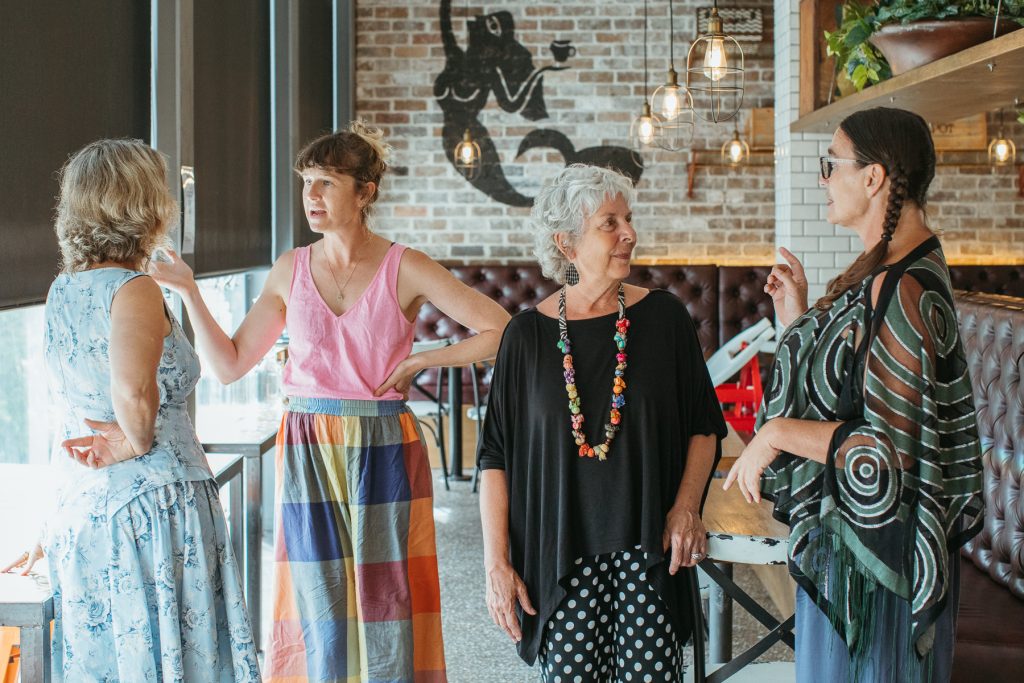 Mid shot of four women talking to each other