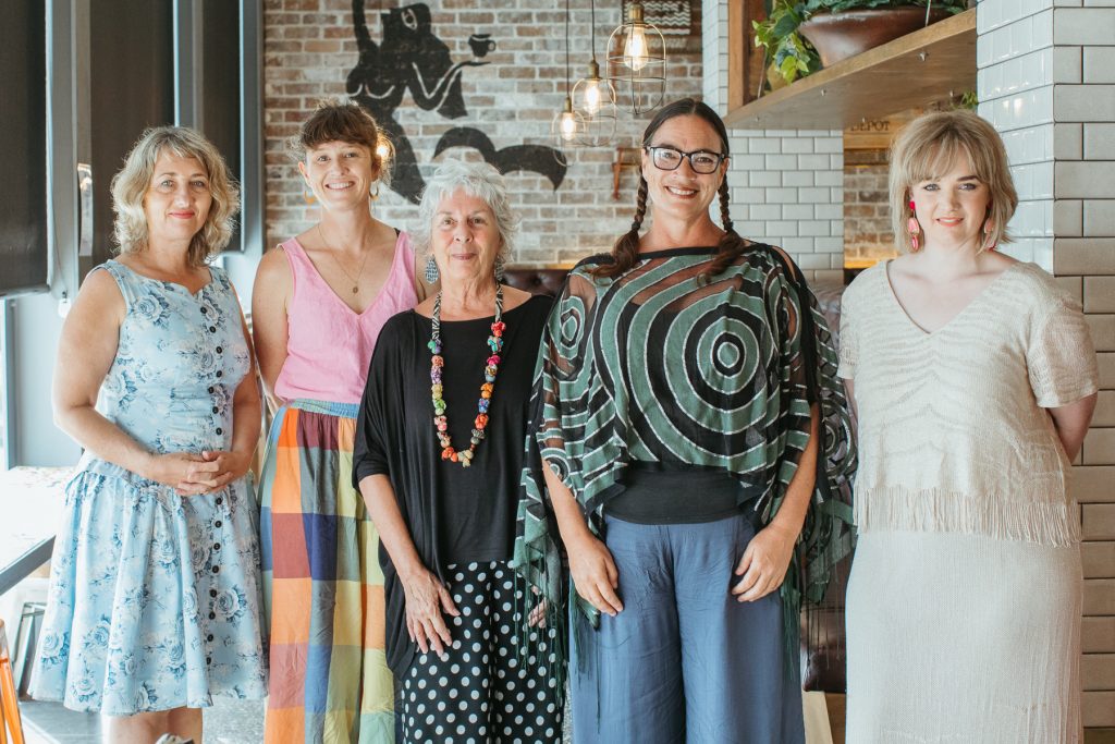 Mid shot of five women smiling at the camera