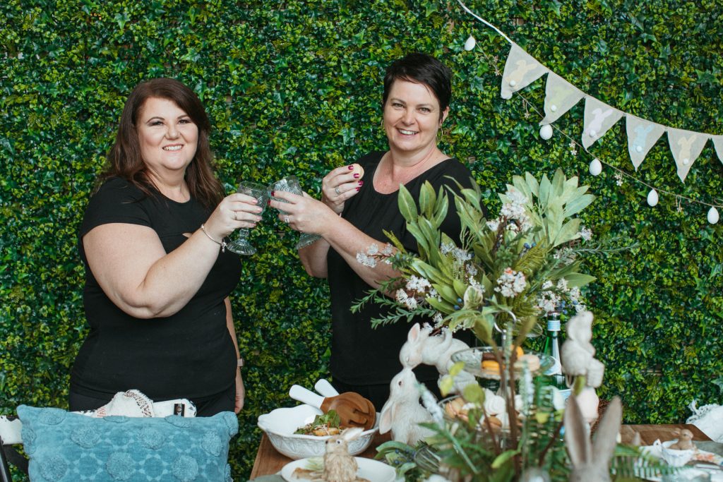 Two women saying cheers and clinking their glasses