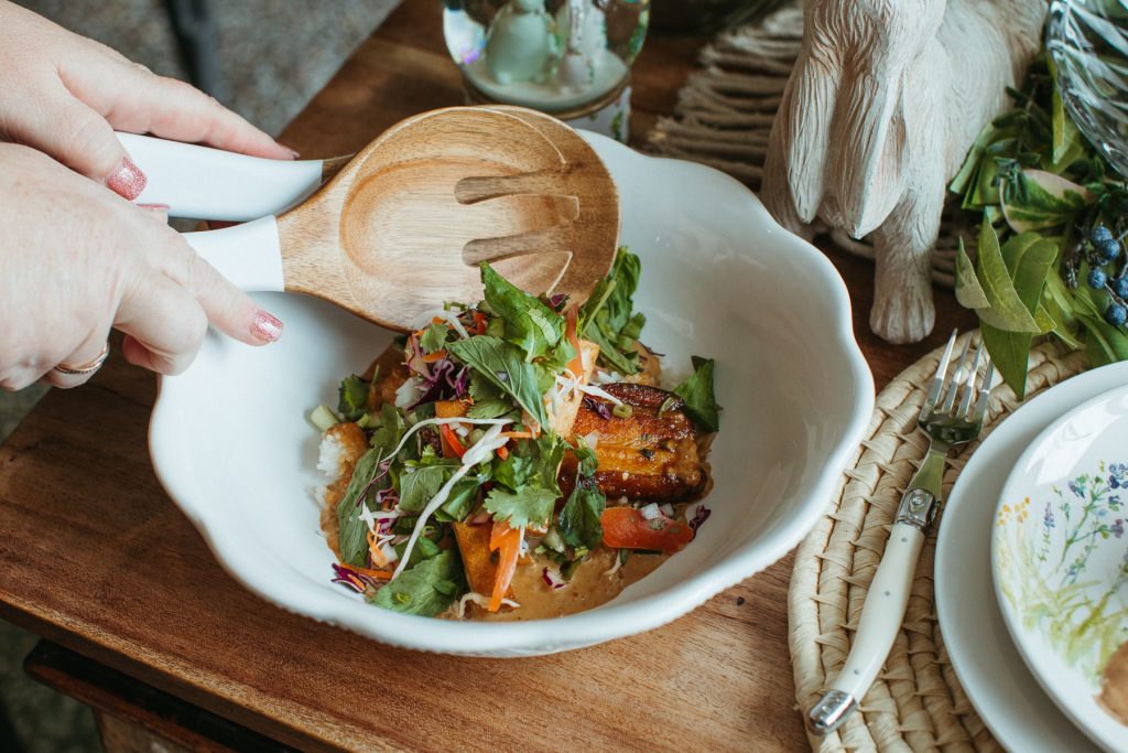 Close up of a bowl of pork belly and salad with rice