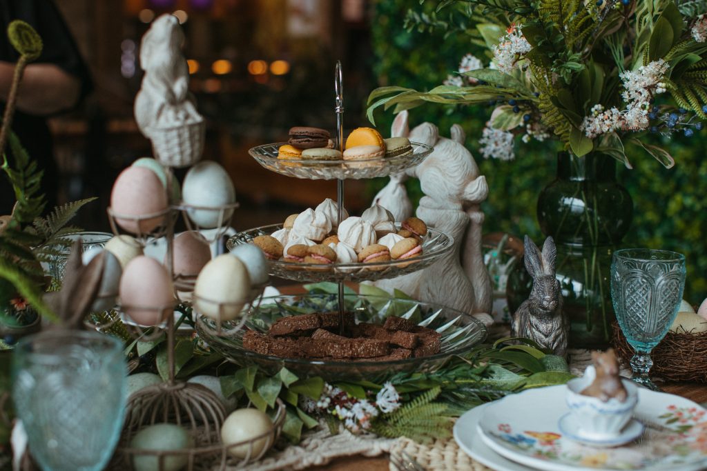 An ornately decorated easter table featuring a tray of colourful macarons