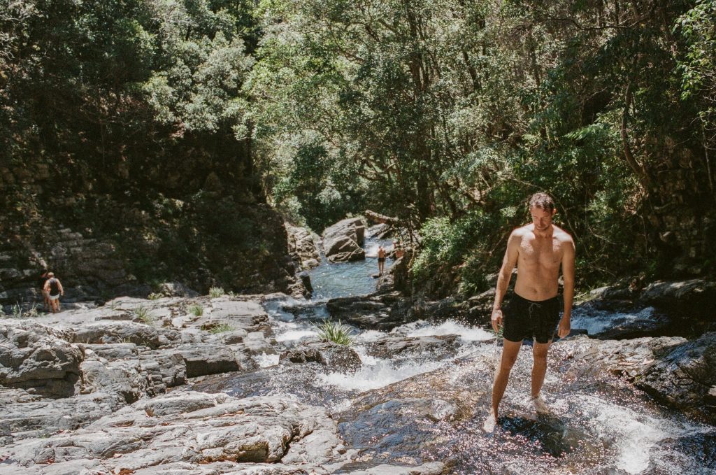 Man standing by a wild swimming hole