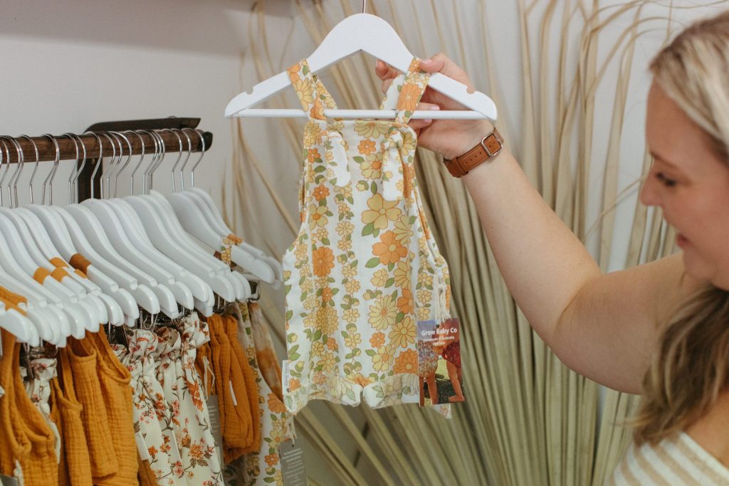 A woman holding handmade baby clothes