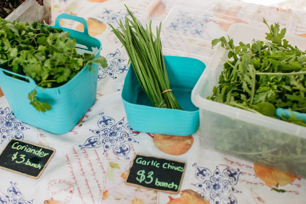 Close up of greens and herbs on a market table 