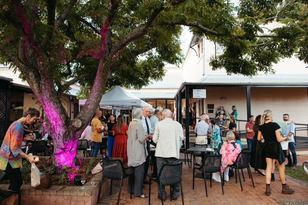 Wide shot of an art gallery courtyard full of people