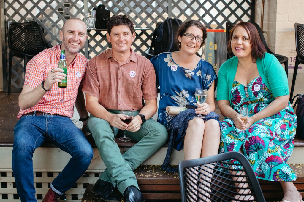 Two men and two women smile and look at the camera