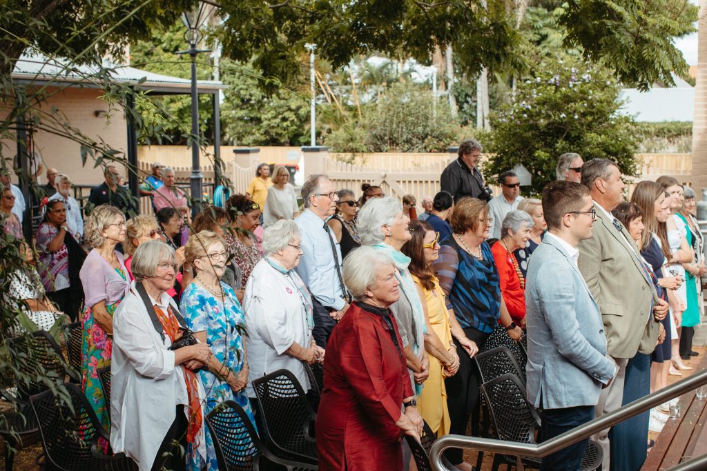 A crowd of people standing in an art gallery courtyard 