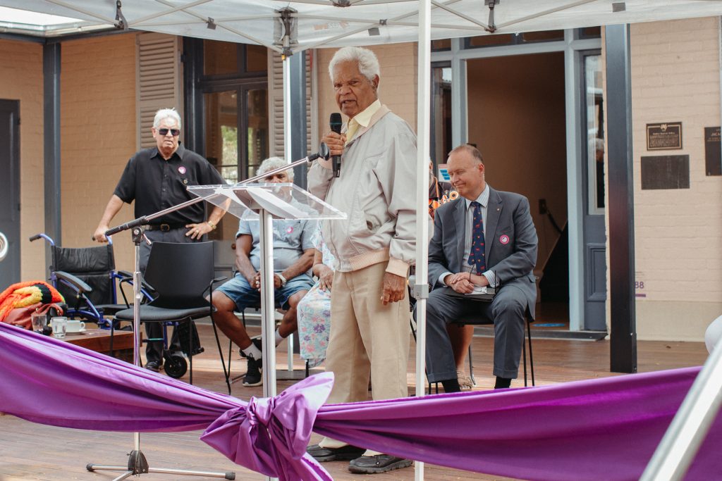 An Aboriginal man speaks in front of a crowd