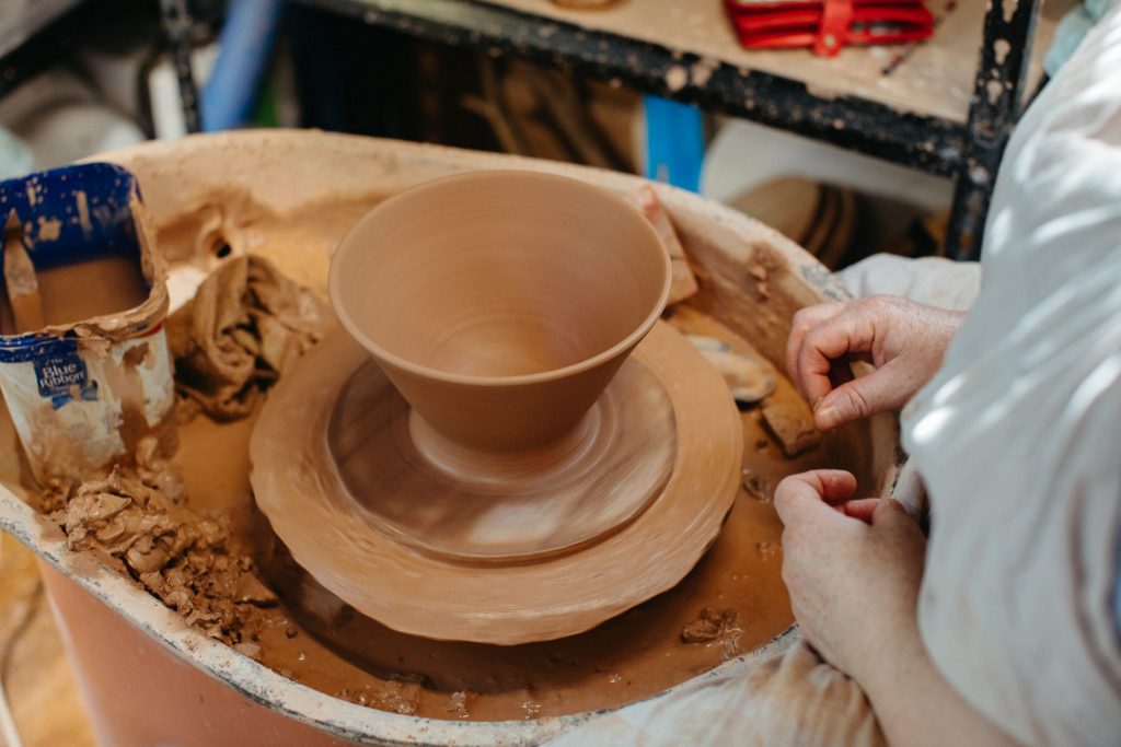 Close up of a person making a pot on a ceramic wheel