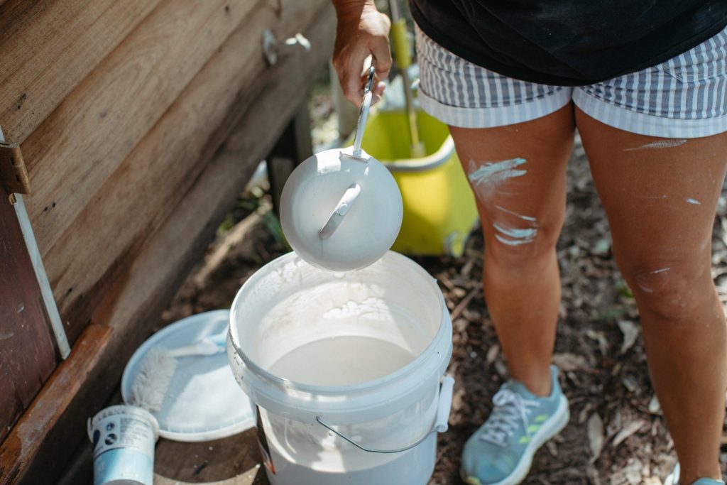 Close up of a woman glazing a ceramic pot