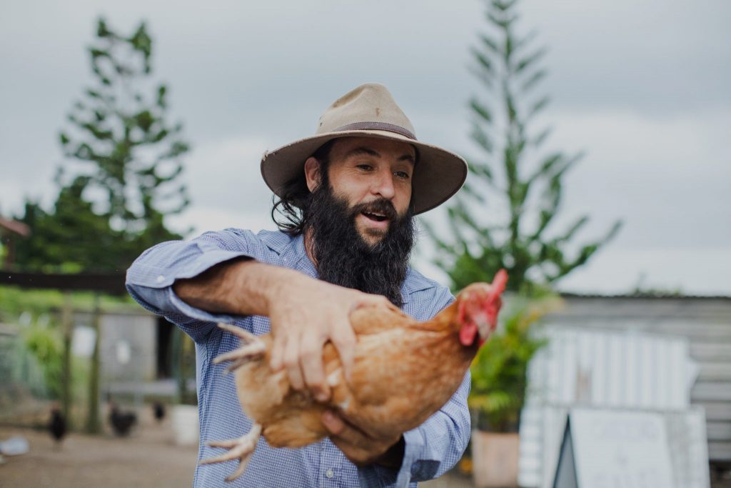 A farmer holding a chicken
