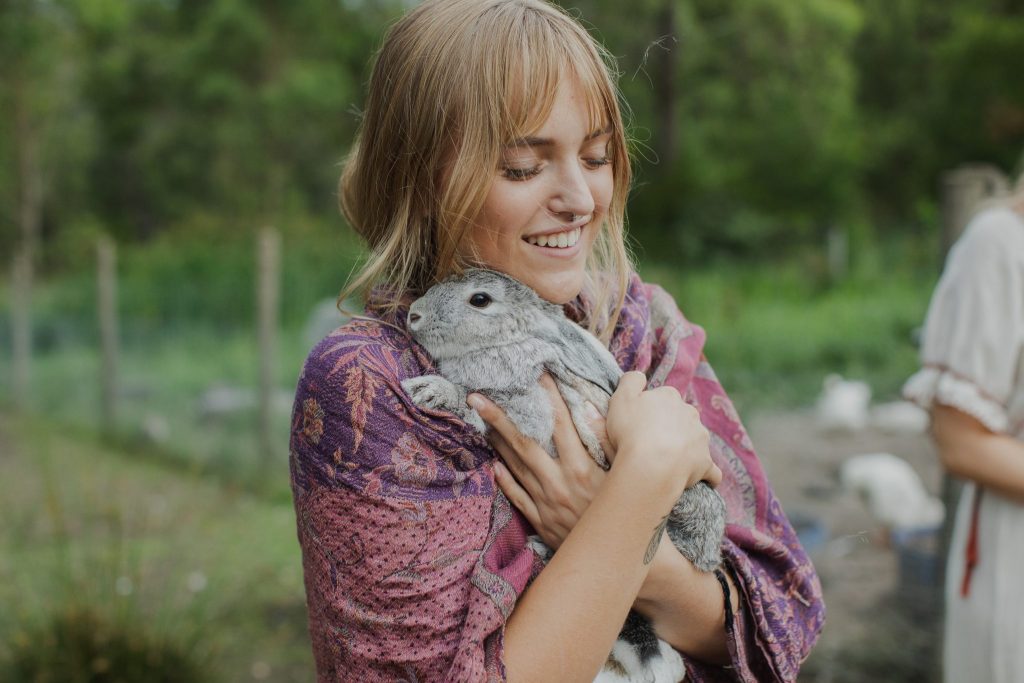 A young woman cuddling a rabbit