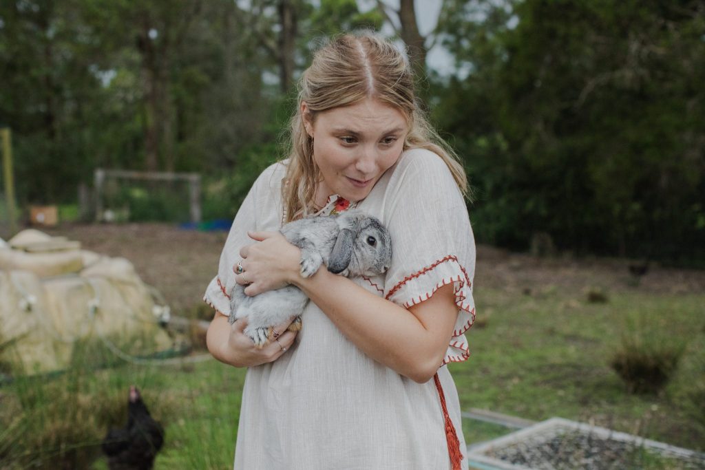 A young woman cuddling a rabbit 