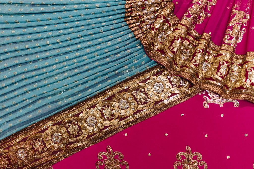 Close up of a pink, blue and gold patterned Indian sari
