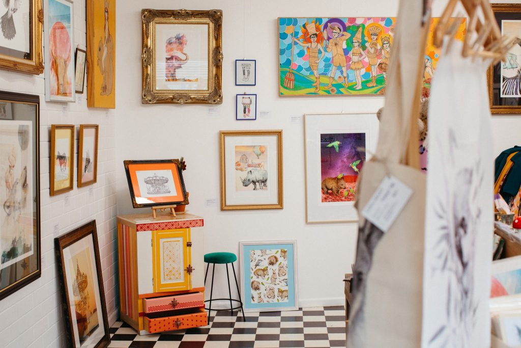 Interior shot of an art gallery full of colourful drawings and paintings