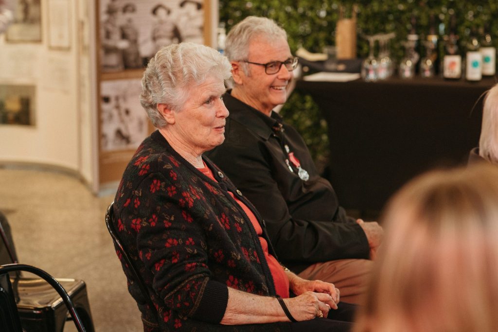 An older couple sitting together in an audience