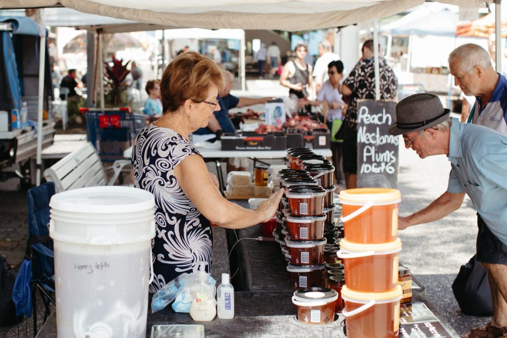 A woman at a market stall selling honey