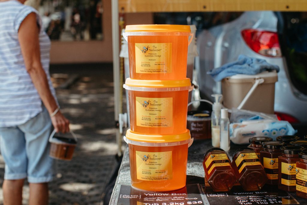 Honey in plastic tubs with yellow lids