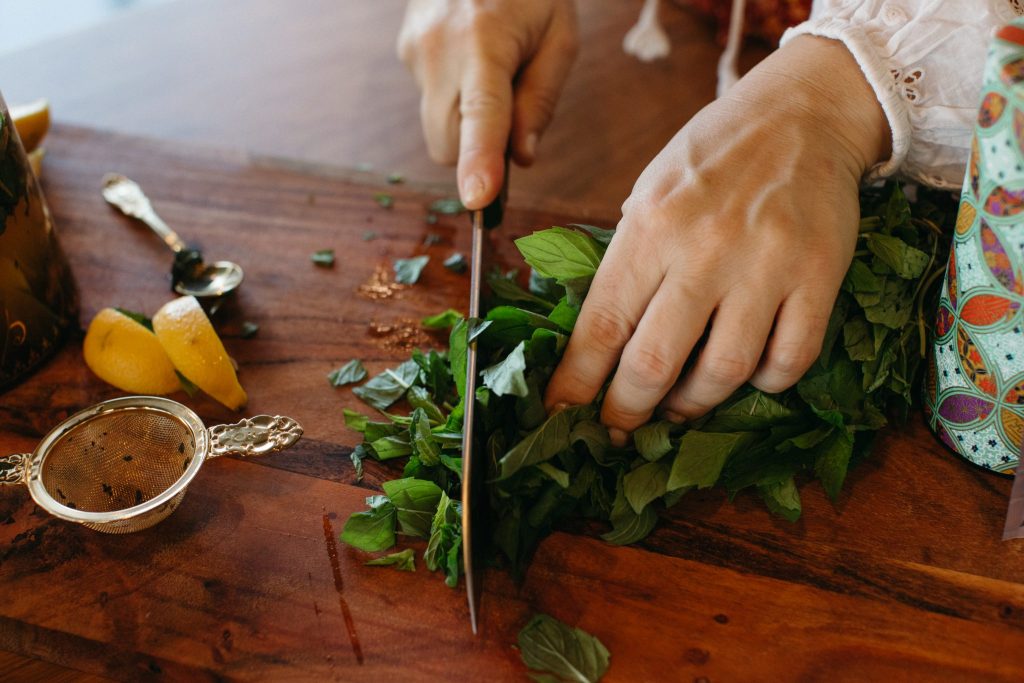 Close up of hands chopping mint leaves