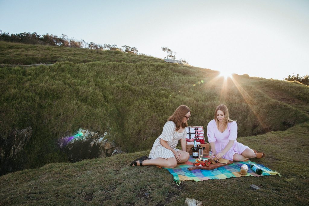 Two young women enjoy a picnic at sunset 