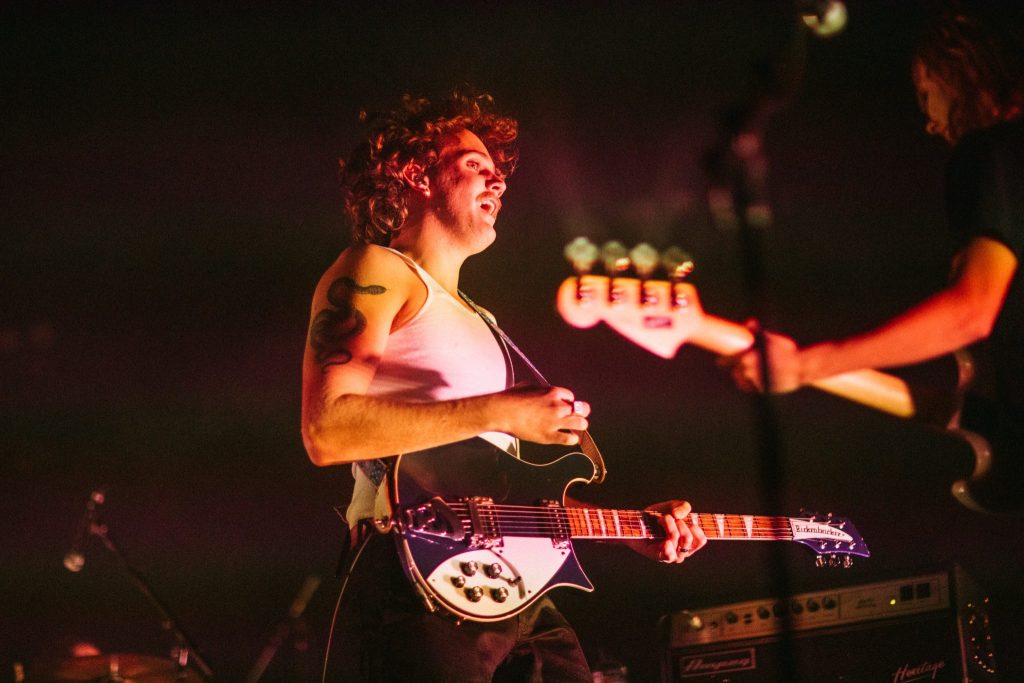 A guitarist performing on stage at a music festival