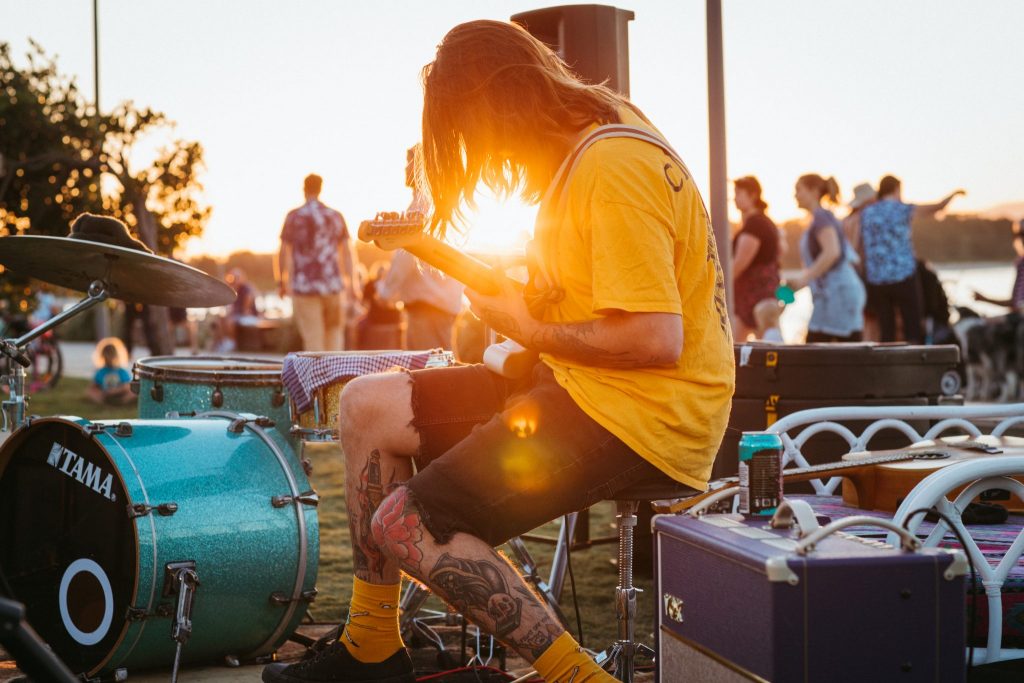 A man playing guitar with the sunset in the background