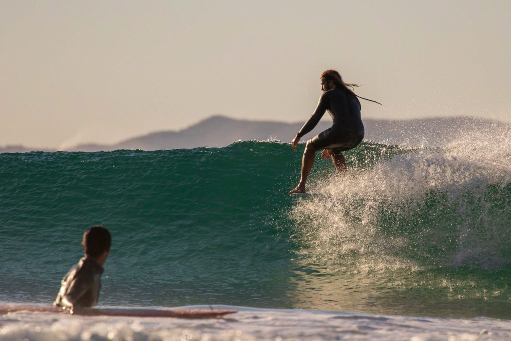 A man riding a wave on the nose of his longboard