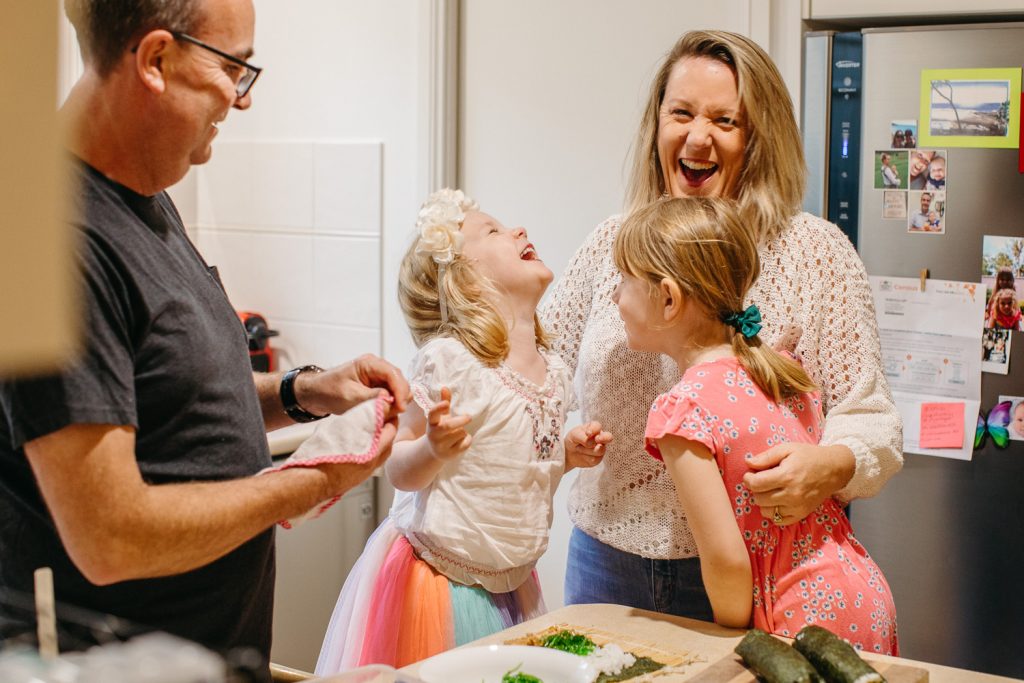 A mum and dad make sushi with two daughters
