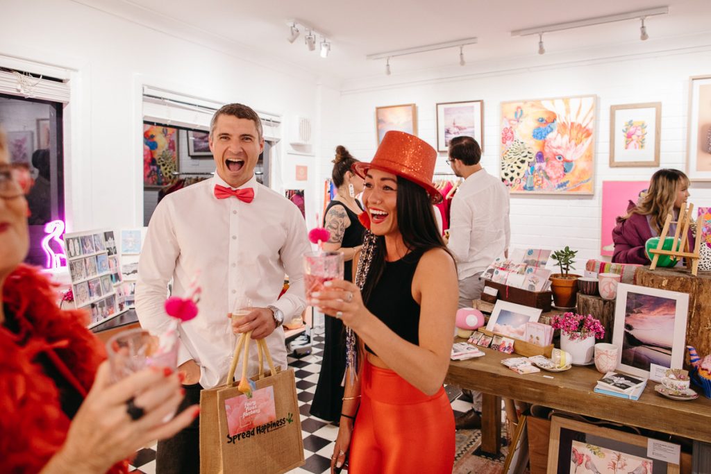 A smiling man and woman in an art gallery 