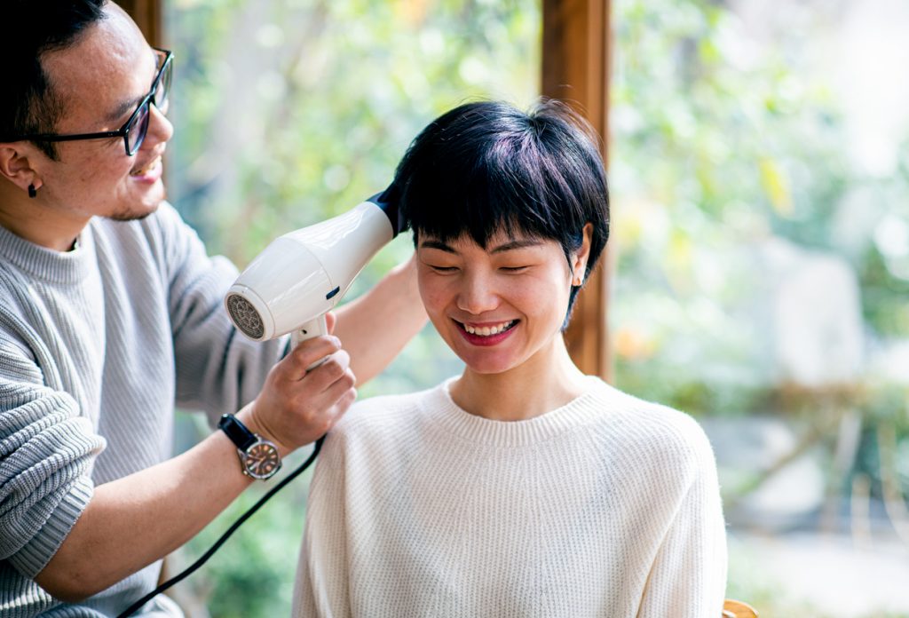 An Asian woman having her hair blow dried
